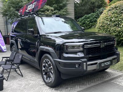 Black SUV with roof rack and surfboard carrier