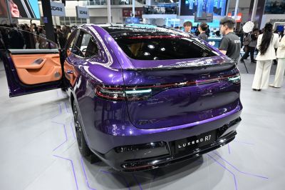 Rear view of purple car with illuminated taillights and open door showing tan interior