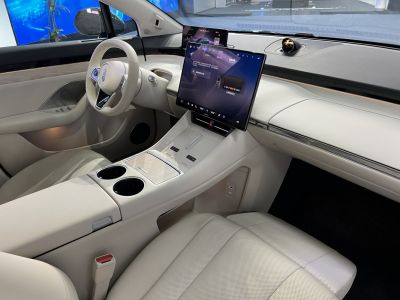 Modern car interior with large touchscreen display and beige upholstery