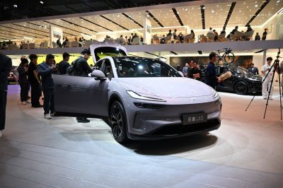 Front view of sleek car with LED headlights and open driver door