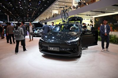 Sleek black vehicle with roof-mounted bicycle and open door