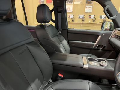 Black leather front seats with modern center console and armrest.