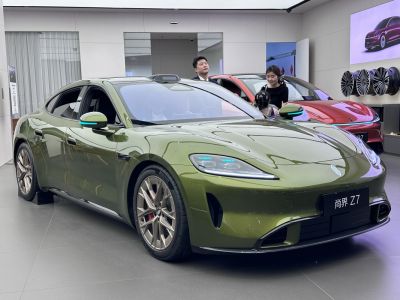 Sleek green electric sedan with LED headlights and aerodynamic design