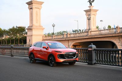 Red SUV with modern grille and sleek headlights near stone bridge