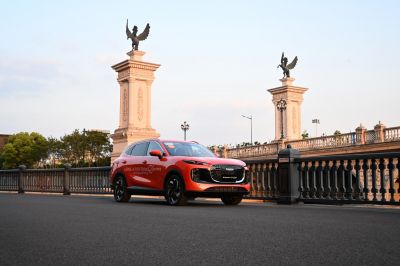 Red SUV front view with alloy wheels on city bridge