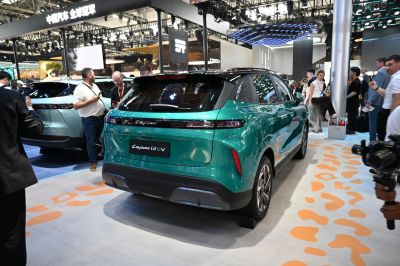 Rear perspective of a green electric SUV with sleek taillights and sporty bumper.