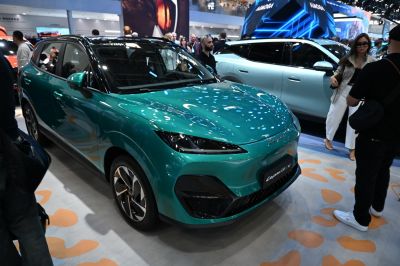 Sleek front and side view of green electric vehicle with futuristic headlights