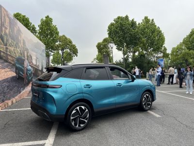 Rear-side view of a blue and black two-tone modern SUV with sleek aerodynamic features.