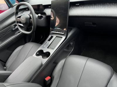 Car interior with large vertical infotainment screen and leather seats