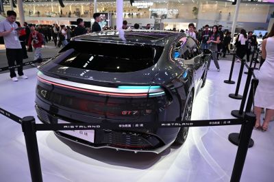 Rear car design with continuous LED light bar and GT7 badge on sleek glossy surface