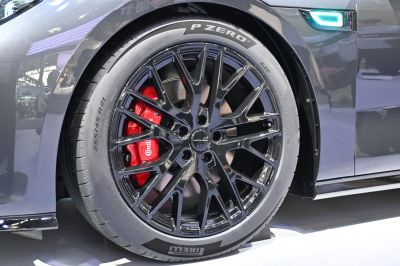 Glossy black multi-spoke alloy wheel with red brake caliper.