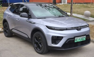 Modern electric SUV front view with split headlights and black alloy wheels