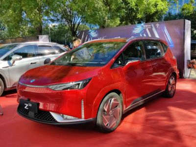 Front and side view of red electric MPV with sharp headlights and aerodynamic wheels