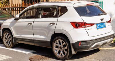 Rear side view of a white compact SUV with angular taillights and alloy wheels