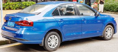 Rear side view of a blue compact sedan with distinctive taillights