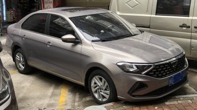 Front side view of a 2019 model compact sedan with angular headlights and alloy wheels