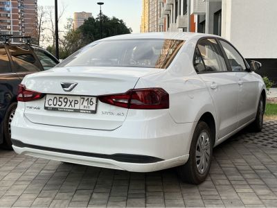 White sedan rear with red tail lights and smooth rear bumper design