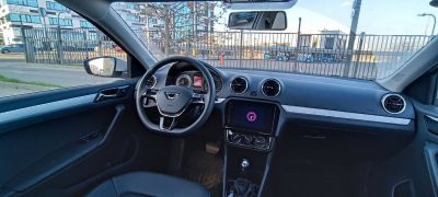 Steering wheel, round air vents, touchscreen, climate control knobs.