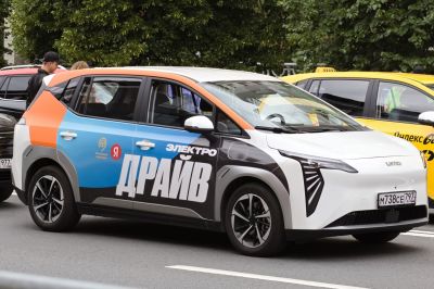 Electric hatchback with angular LED headlights and a multi-color wrap design.