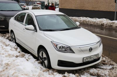 White electric sedan with unique perforated front grille and aerodynamic headlights