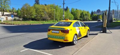 Yellow electric taxi charging roadside at public station