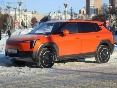 Orange electric SUV with LED headlights and black rugged wheel arches