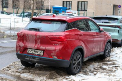Red compact SUV rear with black alloy wheels on snowy street