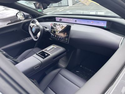 Minimalist car interior with dual digital screens and unique rectangular steering wheel