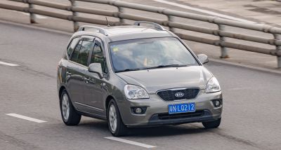 Front and side view of a compact MPV with roof rails in motion.