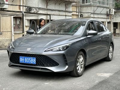 Sharp headlights and large patterned grille on a sleek sedan front.