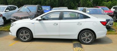 Side profile of a white sedan with alloy wheels and sleek design