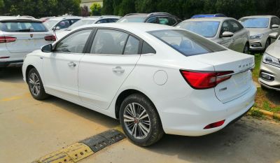 White sedan showcasing rear side profile and tail lights