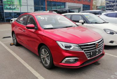Red sedan with modern angular headlights and chrome grille