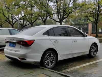 Rear and side view of white sedan with tinted windows and alloy wheels
