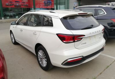 Rear and side view of a white wagon with roof rails and distinctive tail lights