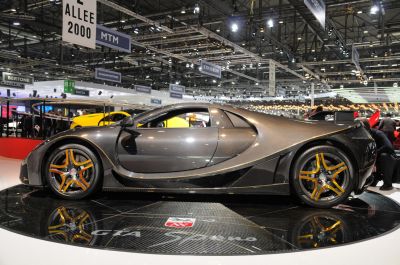 Carbon fiber body and gold-accented alloy wheels on a sleek supercar side profile