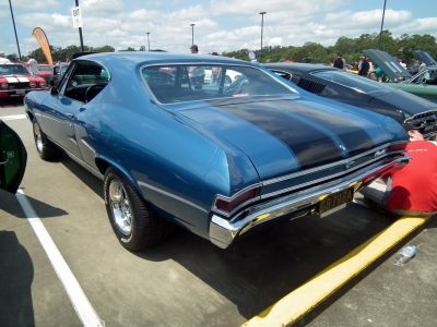 Rear view of muscle coupe with black racing stripes and chrome bumper