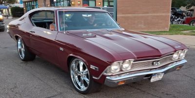Front angled view of vintage muscle coupe with chrome wheels and dual headlights