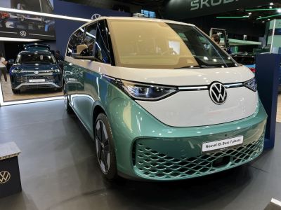 Front view of futuristic electric minivan with LED headlights and unique grille.