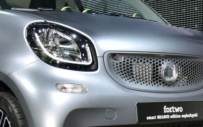 Close-up of front grille with logo and headlight of a compact car