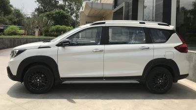 White SUV side view with black alloy wheels and roof rails