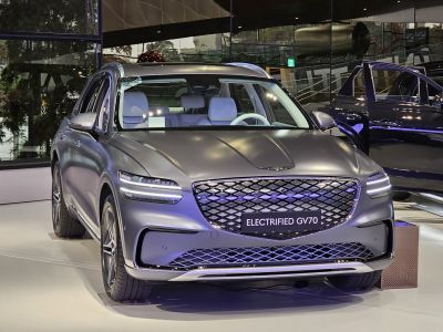 Front view of an electric SUV with LED headlights and large mesh grille