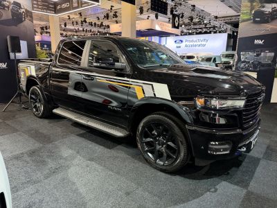 Black pickup with crew cab, black wheels, modern grille, and graphic side decals