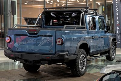 Rear view of rugged pickup with roof rack and all-terrain tires