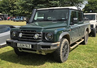 Green off-road SUV with snorkel, round headlights, and rugged tires