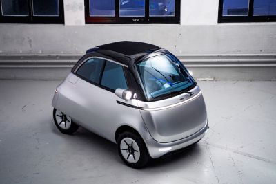 Compact electric vehicle with rounded aerodynamic shape and panoramic windshield
