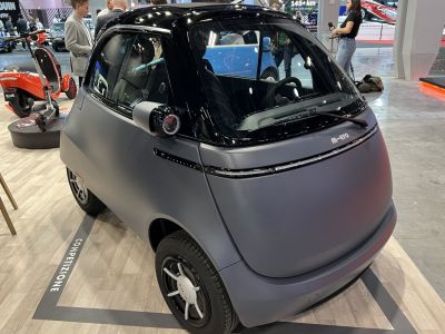 Compact electric microcar with unique front-opening door design and modern styling.