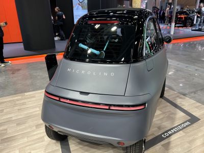 Rear view of compact electric vehicle with sleek tail light strip and minimalist design