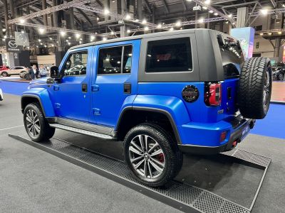 Blue SUV side view with rear spare tire and alloy wheels