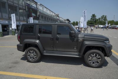 Matte black rugged SUV with four doors and alloy wheels.